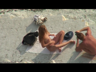 a couple is photographed naked on the beach, peeped